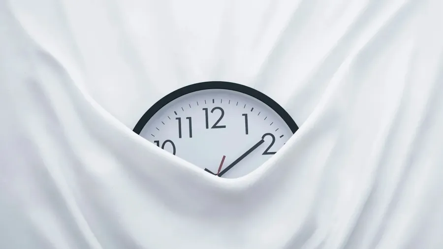 Eine Wanduhr, halb unter weissem Stoff verborgen